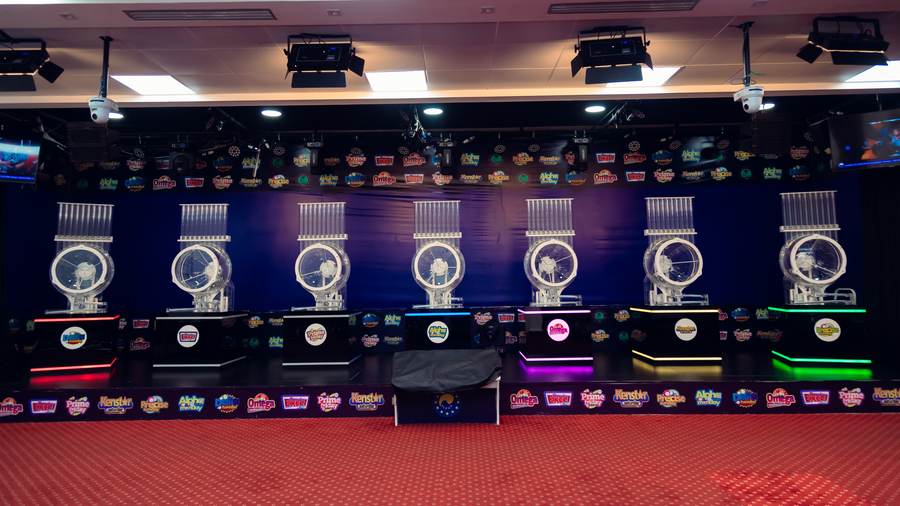 Draw machines lined up on the studio stage, each with its game logo lit beneath it